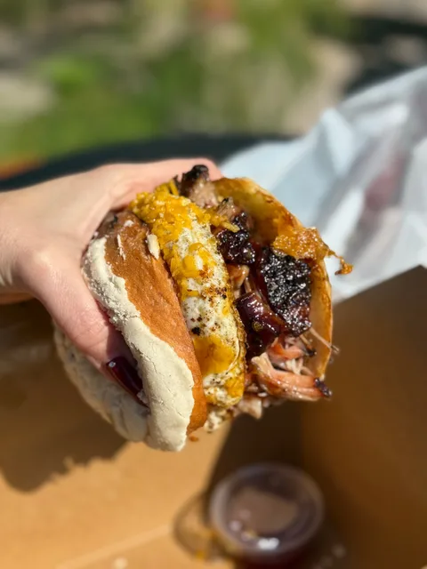 A handheld Chavo Concha showing smoked meat and egg inside the sweet concha bun