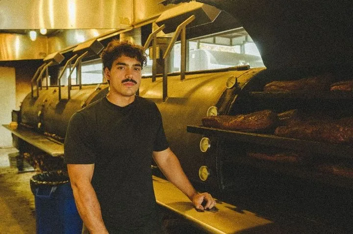 Ivan standing alongside a row of barbecue smokers